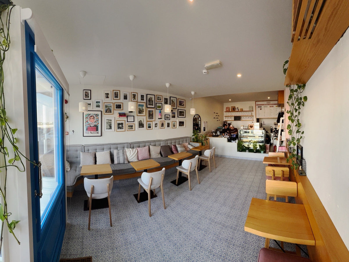 Inside the Frame café: wooden tables, framed pictures on the wall and the counter at the back